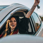 Переклад водійського посвідчення: Молода жінка сидить за кермом і радіє своєму водійському посвідченню